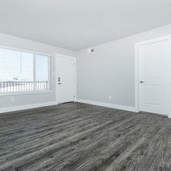 Large living room with plank flooring at Carlson Apartments, located in Colorado Springs, CO