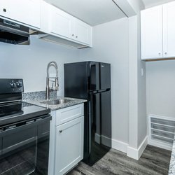 All-electric kitchen with black appliances in one bedroom apartment at Carlson Apartments, located in Colorado Springs, CO