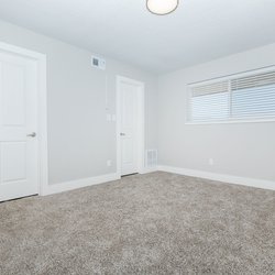 Carpeted bedroom with central air conditioning at Carlson Apartments, located in Colorado Springs, CO